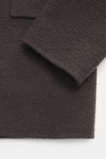 Close-up detail of The Row Cashmere Blouson 'Olek' schwarz, showing the soft, airy cashmere felt fabric from a top-down perspective with visible texture and overlapping sleeves. Meisterhafte Handwerkskunst in doppelter Verarbeitung von THE ROW: Der weiche