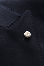 Nahaufnahme des Spitzrevers mit weißem Revers-Pin des Luigi Bianchi Sakko navy aus reiner Schurwolle, Slim Fit, zweireihig.