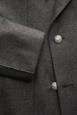 Nahaufnahme des Luigi Bianchi Sakko dunkelgrau meliert aus Schurwolle und Cashmere, Slim Fit, zweireihiger Drei-Knopf-Stil mit Wappen-Knöpfen, spitzem Revers, halb gefüttert, fotografiert aus seitlicher Perspektive.