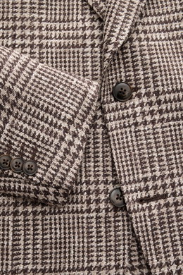 Nahaufnahme des Luigi Bianchi Sakko dunkelbraun/beige kariert mit Prince-of-Wales-Muster, Knöpfen und fallendem Revers, schräg fotografiert.