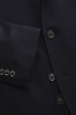 Close-up front view of the Brioni Jersey blazer navy showing the soft cashmere and silk jersey fabric, slim fit, tailored three-button style, notched lapel, leather collar trim with embossed logo, classic chest pocket, patch hip pockets, kissing buttons, 