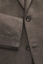 Nahaufnahme des Brioni Sakko 'Ravello' graubraun meliert aus reiner Schurwolle, taillierter Zwei-Knopf-Stil mit fallendem Revers, fotografiert von vorne.