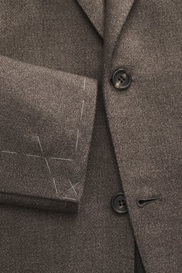 Nahaufnahme des Brioni Sakko 'Ravello' graubraun meliert aus reiner Schurwolle, taillierter Zwei-Knopf-Stil mit fallendem Revers, fotografiert von vorne.