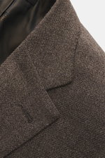 Nahaufnahme des Brioni Sakkos 'Ravello' graubraun meliert, zeigt die feine Schurwoll-Melange und das fallende Revers aus seitlicher Perspektive.