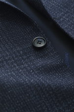 Close-up front view of Brioni Blazer 'Ravello' navy checkered showing wool-silk Glen check fabric and black button.

Italian craftsmanship at its finest: the 'Ravello' blazer by BRIONI impresses with an exquisite blend of wool and silk in a classic Glen c