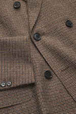 Close-up front view of Ami Paris Blazer khaki/navy checkered showing pure new wool fabric with mini houndstooth weave pattern, slim fit, double-breasted three-button style, peak lapel, hip pockets with flap, sleeve cuffs with buttons, rear side vents, sof