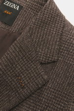 Zegna Sakko dunkelbraun/beige kariert, Nahaufnahme von Revers und Label, fein gewebt aus Cashmere-Seide, weicher Griff, italienische Eleganz.