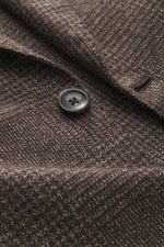 Nahaufnahme des Zegna Sakko dunkelbraun/beige kariert mit feinem Webmuster, weichem Griff und Knopf, Detailfoto aus Frontperspektive.