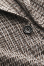 Nahaufnahme des Zegna Cashmere Sakko 'Torino Couture' grau/dunkelgrau gemustert mit Fischgrat-Webmuster und Knopf, Detailfoto der weichen Oasi Cashmere-Fasern.