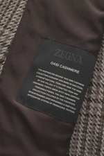 Nahaufnahme der Innenansicht des Zegna Cashmere Sakko 'Torino Couture' grau/dunkelgrau gemustert, Stofflabel und Futter mit Fischgratmuster sichtbar.