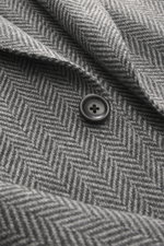 Nahaufnahme des Zegna Cashmere Sakko 'Torino Couture' graubraun kariert mit Glencheck-Muster und Knopf, zeigt die feine Oasi Cashmere-Struktur.