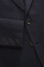 Close-up front view of Zegna Blazer 'Couture' navy/black patterned with classic herringbone, cashmere-silk blend, slim fit, two buttons, notched lapel, and detailed stitching.