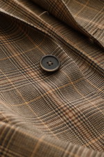 Close-up shot of the Barena Venezia Light brown/black checked blazer fabric, showing pure new wool, soft touch, noble Prince-of-Wales woven pattern, slim fit, tailored two-button style, notched lapel, classic breast pocket, patch hip pockets, kissing butt