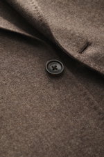 Nahaufnahme des graubraun melierten Windsor Sakko 'Giro' mit Fokus auf Knopf und feiner Webstruktur, weicher Griff, Slim Fit, fallendes Revers, Zwei-Knopf-Stil, klassische Brusttasche, aufgesetzte Hüfttaschen, Kissing Buttons, rückwärtige Seitenschlitze, 