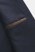 Nahaufnahme des navyfarbenen Windsor Sakkos 'Tesso' mit feinem Wollgewebe, weichem Griff und sichtbarer aufgesetzter Brusttasche, fotografiert aus schräger Perspektive.