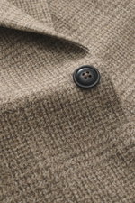 Nahaufnahme des beigen karierten Circolo 1901 Jersey-Sakkos mit schwarzem Knopf, Jersey-Baumwolle, weichem Griff und Print in Weboptik.