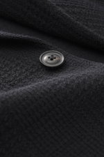 Nahaufnahme aus schräger Perspektive des Circolo 1901 Strickblazer dark navy mit markantem Prince-of-Wales Muster, weichem Woll-Mix, Knopf und feiner Struktur.