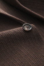 Nahaufnahme eines dunkelbraunen Circolo 1901 Strickblazers aus Woll-Baumwoll-Mix mit markantem Strick, Knopf und weichem Griff.