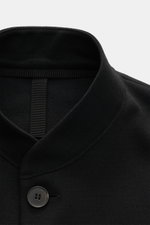 Close-up front view of the standing collar and button of the Harris Wharf London Jersey jacket black, showcasing its pure virgin wool fabric. 

<p>The elegant look of a smart-casual jacket meets the comfort of a sweat jacket – HARRIS WHARF LONDON has achi