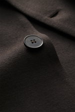 Close-up side view of a dark brown Harris Wharf London Jersey jacket showing its button and fine virgin wool fabric texture.

<p>The elegant look of a smart-casual jacket meets the comfort of a sweat jacket – HARRIS WHARF LONDON has achieved this fusion o