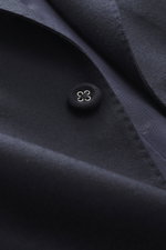 Nahaufnahme des Officine Générale Sakkos 'Michel' navy, seitliche Perspektive auf feinen Twill aus reiner Wolle, weicher Griff, Kissing Button aus Cord sichtbar.