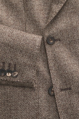 Nahaufnahme des Santaniello Sakko beige/braun meliert aus feiner Wolle mit Cashmere, slim fit, zweireihig, mit Knöpfen und markantem Webmuster, fotografiert aus leichter Vogelperspektive.