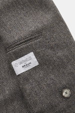 Nahaufnahme aus schräger Perspektive des Santaniello Sakko dunkelbraun/taupe gemustert mit Fischgrat-Muster, Wolle-Cashmere-Mix und Wappenknopf.