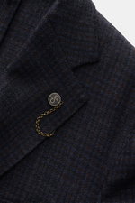Close-up frontal view of the Santaniello Blazer navy/dark brown checked showing pure wool fabric, subtle check pattern, notched lapel, and branded button with chain.