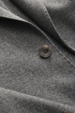 Close-up front detail of Santaniello Blazer grey melange showing pure wool fabric texture and single button, photographed from above. 

Description: <p>Always well dressed: This noble blazer from SANTANIELLO made of pure wool in a harmonious melange relia