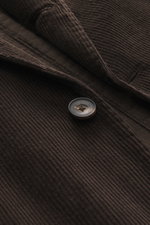 Close-up front view of the Santaniello Cord Blazer dark brown showing soft cotton-cashmere corduroy fabric, a button, and detailed stitching.