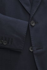 Nahaufnahme des Santaniello Sakko navy aus leicht elastischem Baumwoll-Twill, Slim Fit, tailliert mit fallendem Revers und Kissing Buttons, fotografiert aus seitlicher Perspektive.