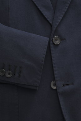 Nahaufnahme des Santaniello Sakko navy aus leicht elastischem Baumwoll-Twill, Slim Fit, tailliert mit fallendem Revers und Kissing Buttons, fotografiert aus seitlicher Perspektive.