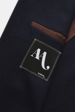 Close-up view of the Doppiaa Blazer 'Aanversa' navy showing the wool and cashmere jersey fabric, classic breast pocket, and inner label, highlighting its slim fit, double-breasted two-button style, notch lapel, patch hip pockets, sleeve cuffs with button,