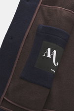 Close-up inside view of Doppiaa Jacket 'Aarneis' navy showing doubleface jersey of cashmere, virgin wool, microfiber, five-button placket, turn-down collar, slanted welt pockets, sleeve cuffs with button tab, half lined, and two inside pockets with label.