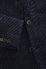 Close-up front perspective of the 04651/ A trip in a bag Cord Blazer navy showing cord microfiber, slim fit, two-button style, notched lapel, patch hip pockets, side label, rear vents, buttoned cuffs, unconstructed design, and inner pockets.