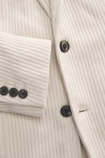 Close-up front view of 04651/ A trip in a bag Cord Blazer sand showing corduroy microfiber fabric, black buttons on sleeve cuffs, notched lapel, slim fit, tailored two-button style, patch hip pockets, small woven label in side seam, rear side vents, uncon