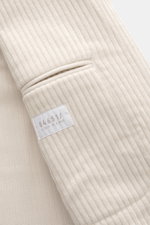 Close-up side view of the sleeve cuff and patch hip pocket of the 04651/ A trip in a bag Cord Blazer sand, showing corduroy made of high-quality microfiber, light elastic quality, slim fit, tailored two-button style, notched lapel, patch hip pockets, smal
