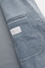 Close-up front view of the sleeve and pocket of the 04651/ A trip in a bag Cord Blazer Smoke Blue, featuring cord made of high-quality microfiber, light elastic quality, slim fit, tailored two-button style, notched lapel, patch hip pockets, small woven la