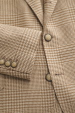 Close-up front view of Brunello Cucinelli Beige/light brown checked blazer showing Prince of Wales check pattern, slim fit, three-button style, notched lapel, classic breast pocket, hip pockets with flaps, small ticket pocket, sleeve cuffs with buttons; m