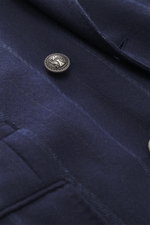 Close-up detail of silver button and fabric texture on the Brunello Cucinelli Navy striped blazer, shot from a front angle, featuring virgin wool and cashmere mix, soft touch, subtle striped pattern, Slim Fit, double-breasted three-button style, peak lape