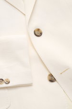 A close-up front view of the Ami Paris Smart-casual jacket cream showing the slim-fit cream viscose-linen blend fabric with a step lapel, two-button style, classic breast pocket, hip flap pocket, and buttoned cuffs. Versatility for summer: This smart-casu