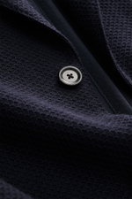 Close-up front view of the Lardini Knitted Blazer Navy button, knit from wool with soft touch, slim fit, draped lapel with flower pin, tailored two-button style.