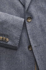Nahaufnahme des Windsor Sakko 'Giorno' rauchblau meliert aus Woll-Microfaser-Mix, Slim Fit, fallendes Revers, Zwei-Knopf-Stil, Kissing Buttons, klassischer Brusttasche, aufgesetzten Hüfttaschen, rückwärtigen Seitenschlitzen, Unconstructed Design und zwei 