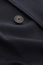 Close-up front view of the Emporio Armani Strickblazer navy, showing a dark button with logo on fine wool knit fabric with tonal herringbone pattern.