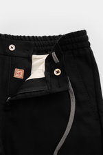 Marco Pescarolo Woll-Jogpants 'Caracciolo' schwarz, Detailfoto von vorne oben mit offenem Reißverschluss, Bundknopf, elastischem Bund, weicher Schurwolle, Regular Fit, schmal zulaufend.