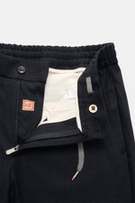 Nahaufnahme der geöffneten Bundpartie der Marco Pescarolo Cashmere Jogpants 'Caracciolo' navy meliert, mit elastischem Bund, Tunnelzug, Zip Fly, Knopf, innen weißem Besatz, von oben fotografiert.