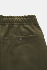 Nahaufnahme der Rückseite der Stone Island Jogpants 'Ghost Piece' dark olive mit elastischem Bund, Knopftasche und weichem Woll-Microfaser-Mix.