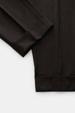 Berwich Wollhose 'Chiaia' dunkelbraun meliert, Detailaufnahme von knöchellangem Bein mit fixiertem Saumaufschlag aus leicht elastischer Schurwolle.