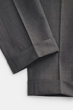 PT Torino Wool Pants 'Rebel Fit' dark grey shown from a close-up overhead perspective, highlighting the elastic virgin wool fabric with slightly textured quality, tapered fit, regular thigh width, ankle-length cuffs, single waistband pleat, and fixed hem 