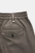 Detailaufnahme von PT Torino Wollhose "The Rebel" dunkelbraun meliert, Rückansicht mit elastischem Bund, geknöpfter Gesäßtasche und Metall-Initial, reine Schurwolle, leicht körniger Griff.